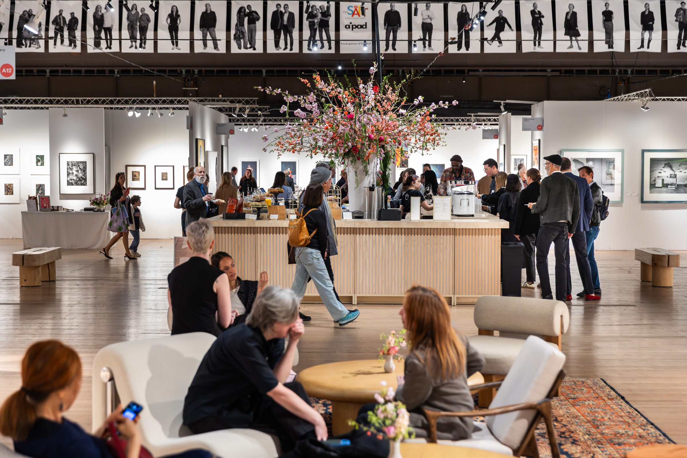 The Photography Show, AIPAD — café and lounge beneath the SALT portrait banners
