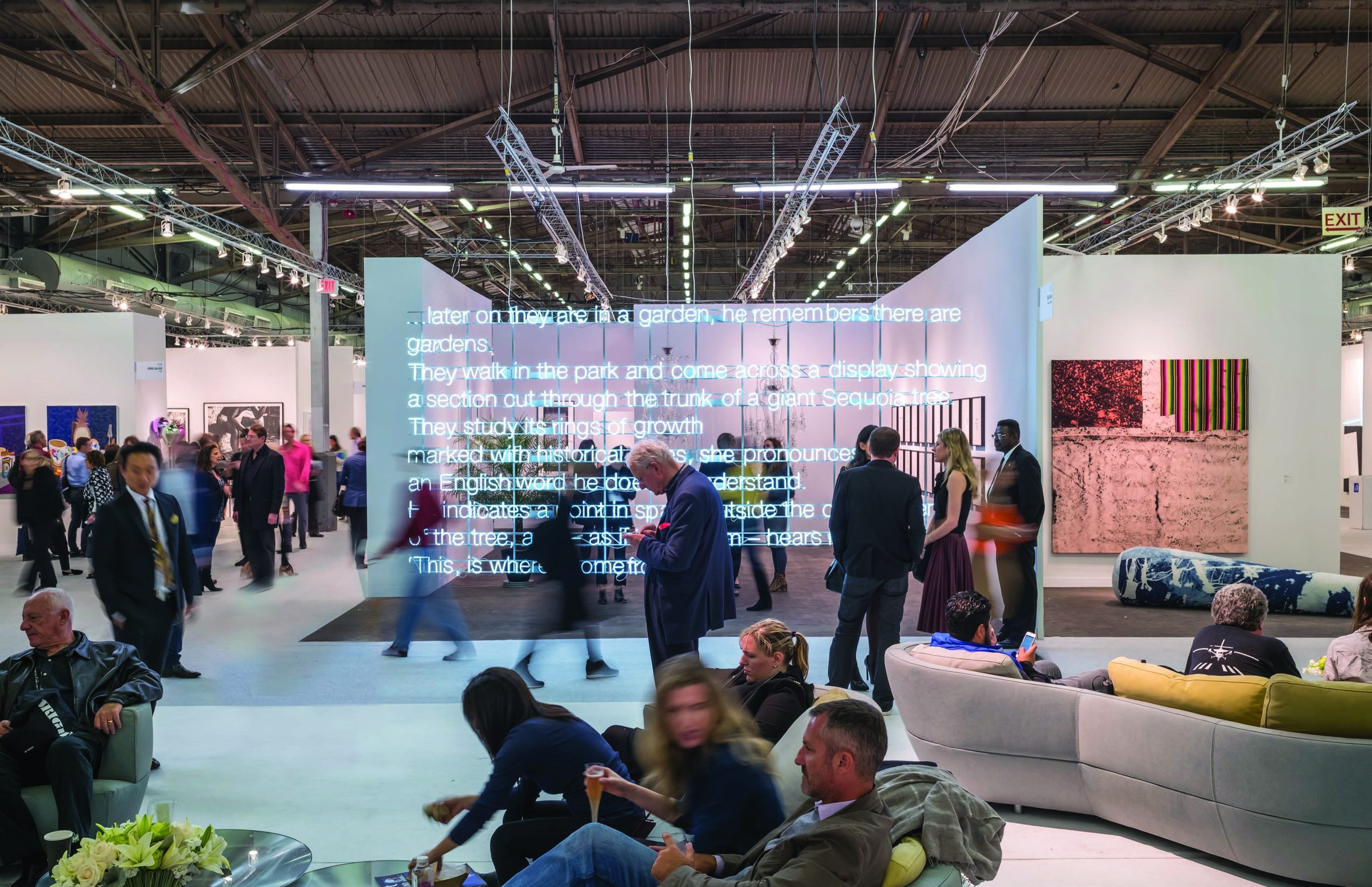 The Armory Show — neon text installation wall with visitors on the fair floor