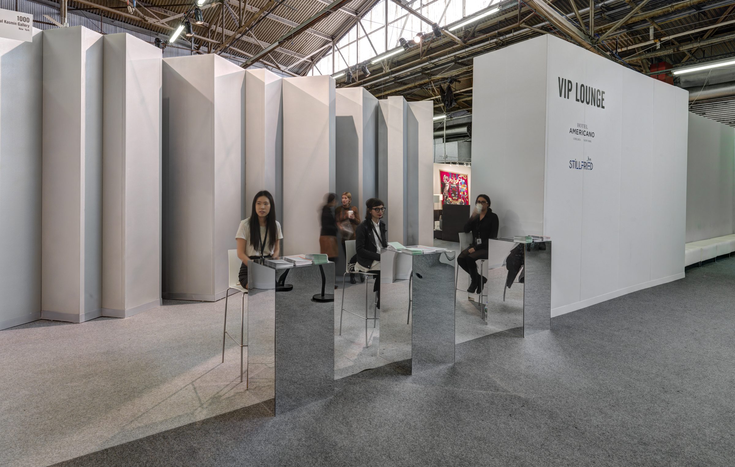 The Armory Show — VIP lounge with angular white walls and mirrored tables
